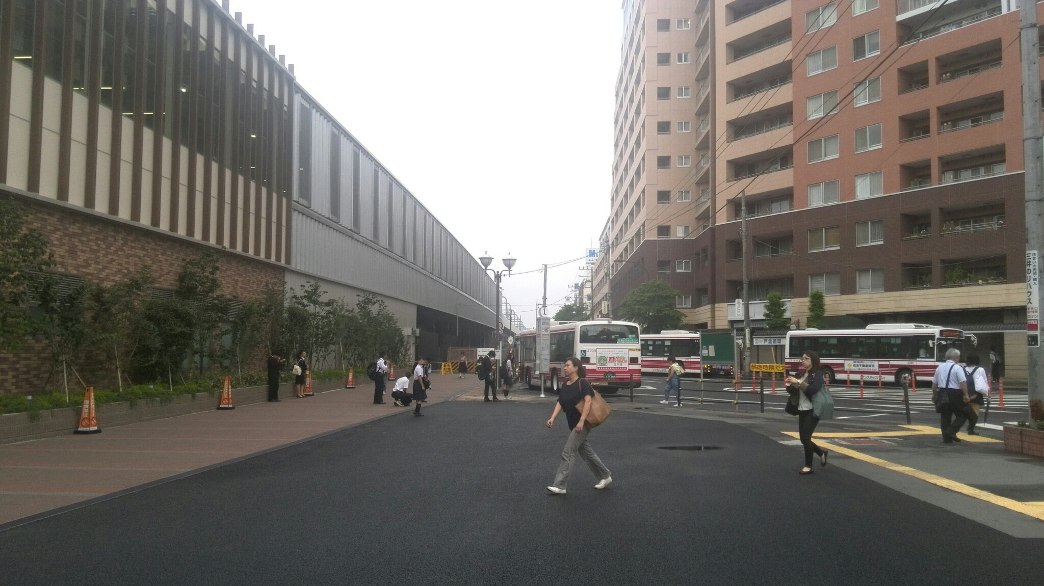 歩行者が行き交う駅前道路