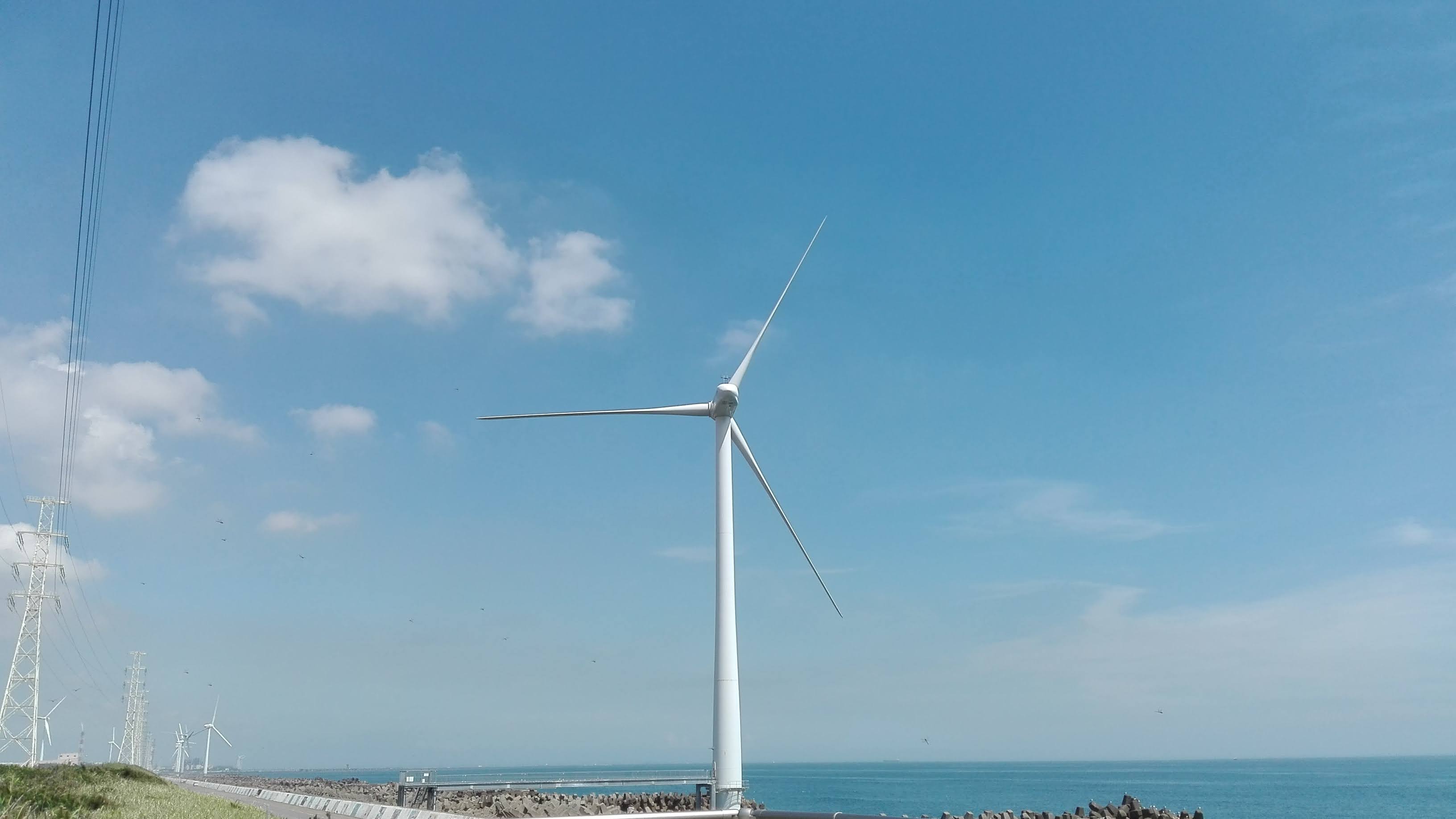 雲の下にそびえる白い風車