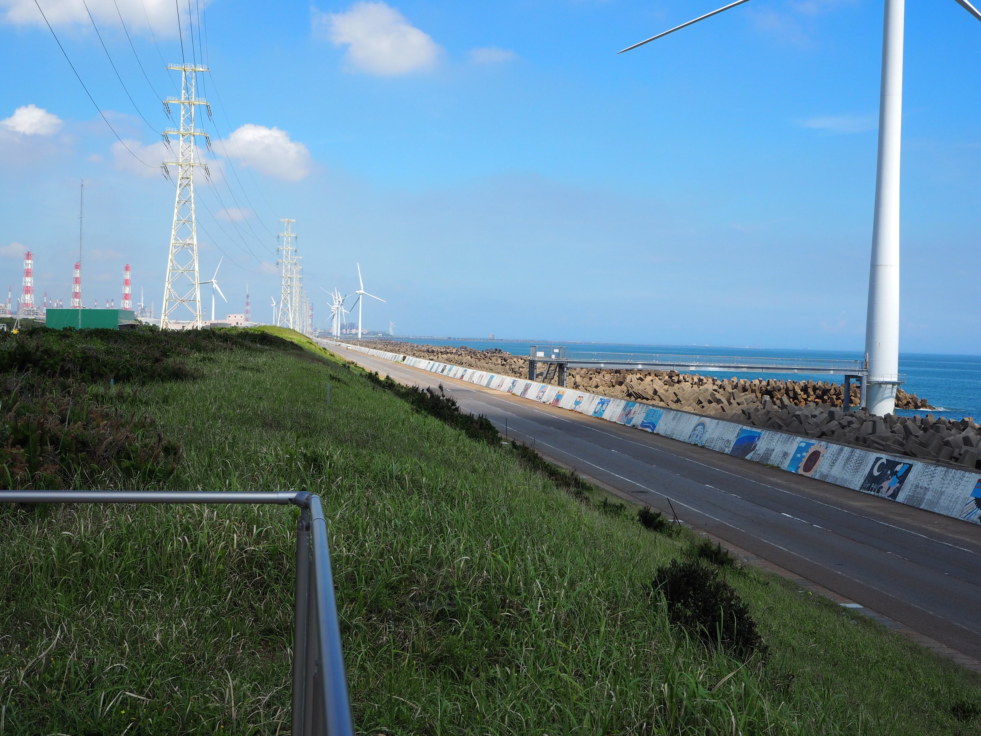 海沿いの道路と風力発電の景色