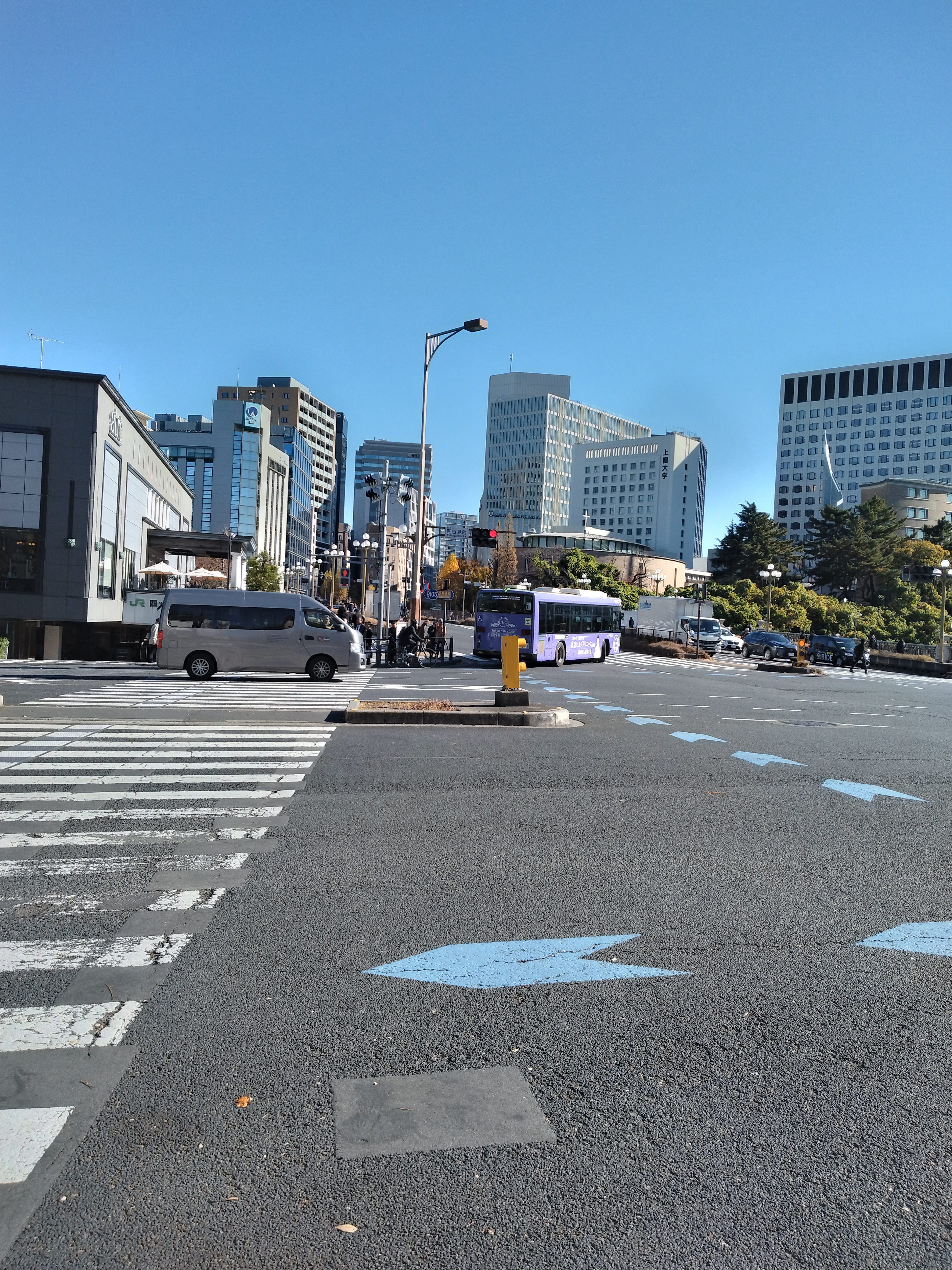 広い直線道路と背後のビル群が写っています。