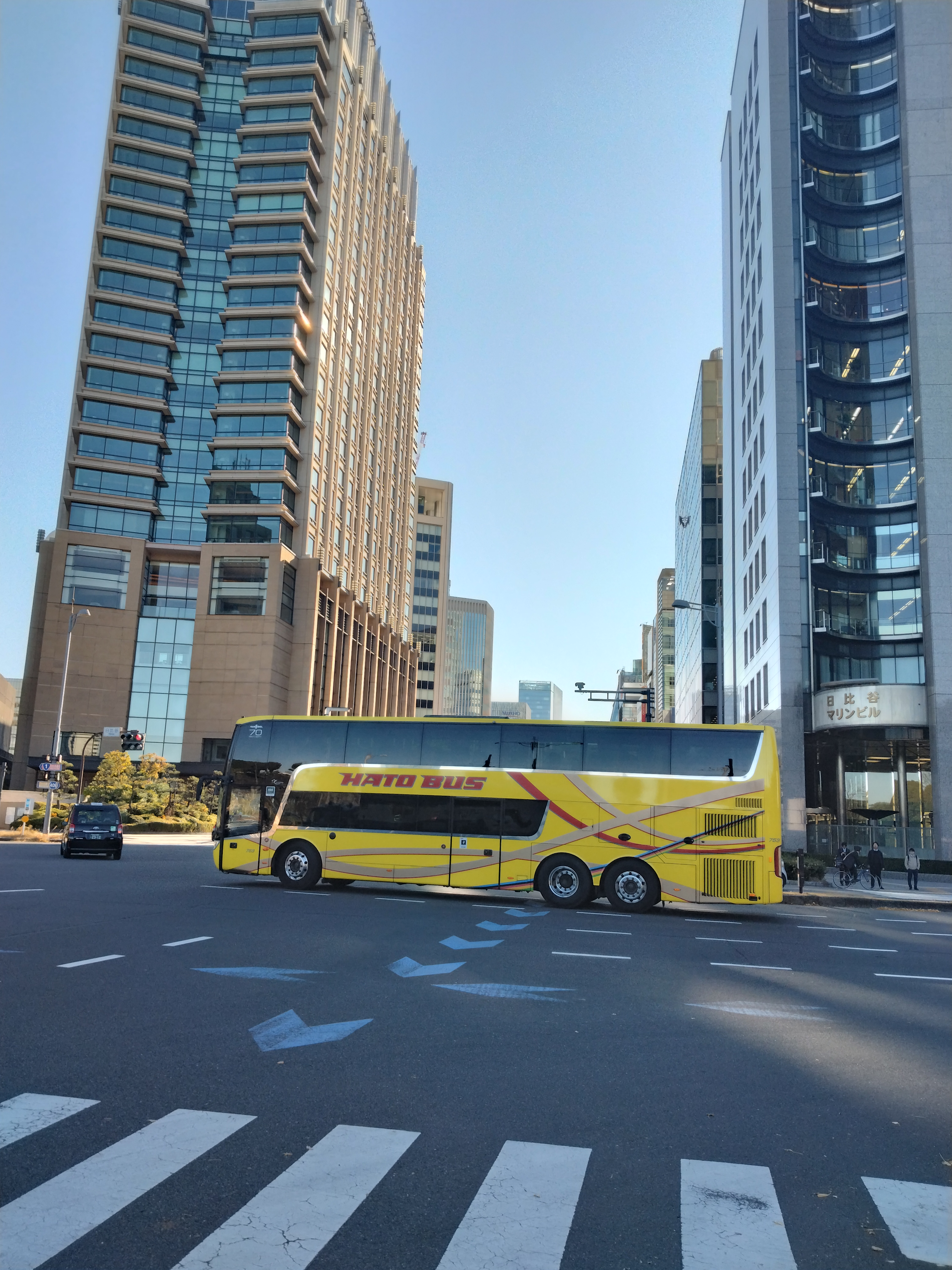 青色の道路標識と高層ビルが写っています。