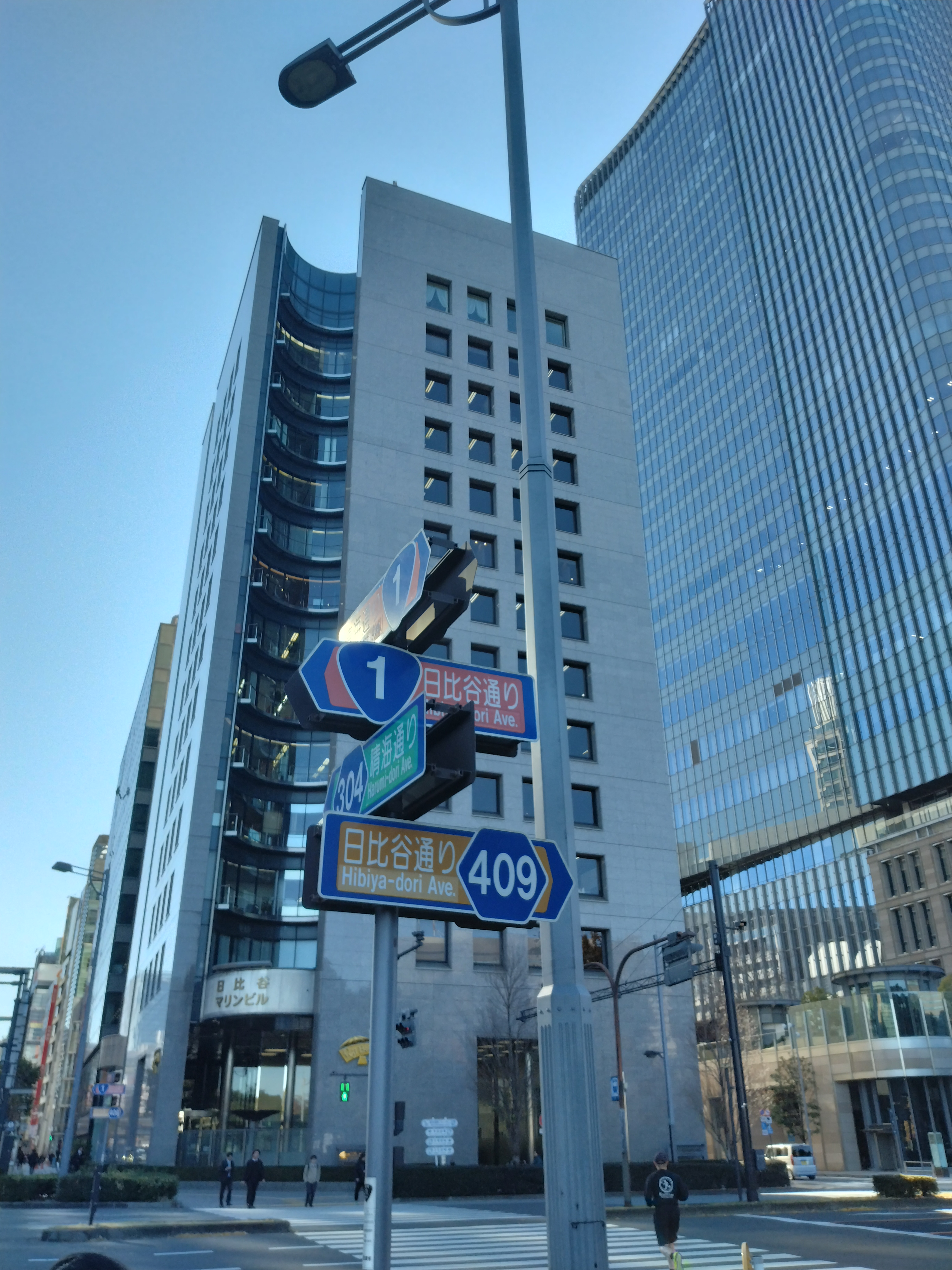 大きな横断歩道とビル群が見える交差点です。