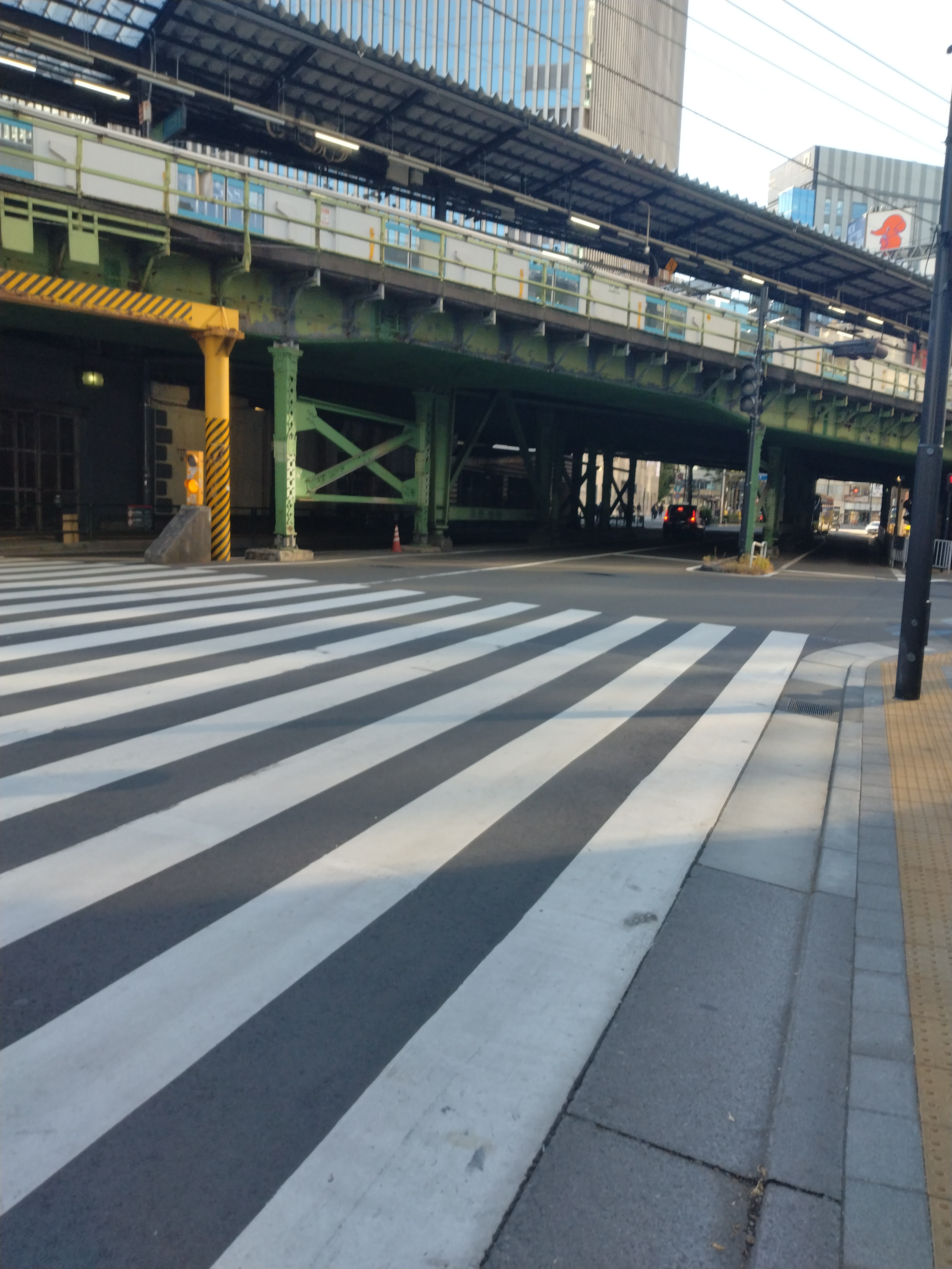 直線的な道路と左右に並ぶビル群が写っています。